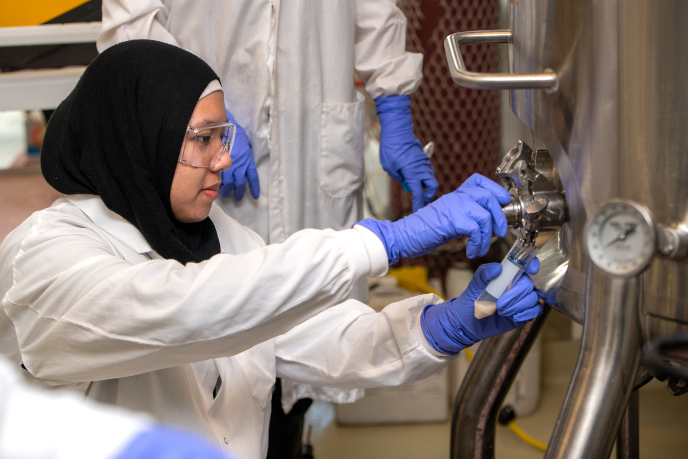 Naura Qotrunnada, UC Berkeley student, makes an adjustment on a gas fermenter.